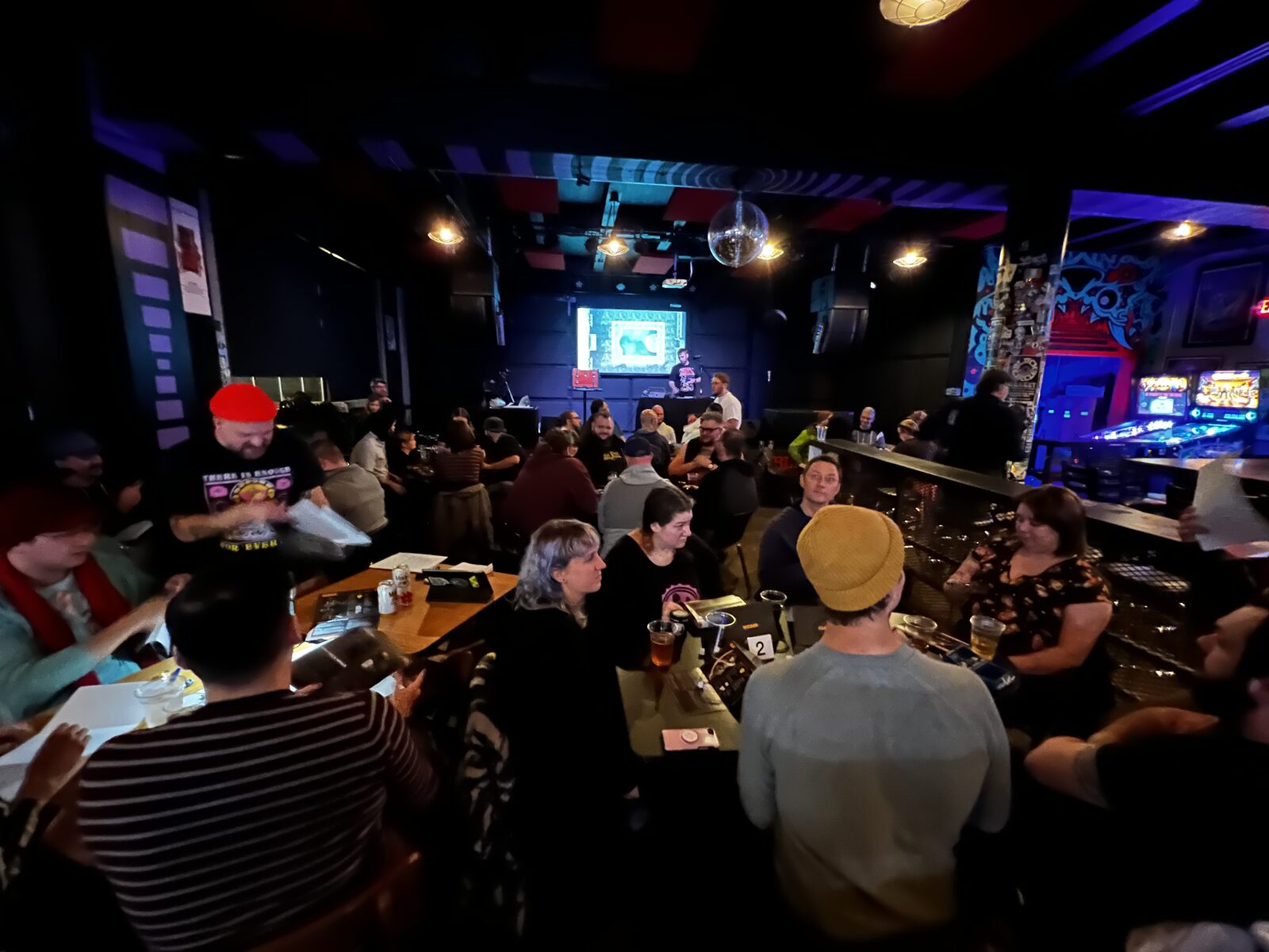 A packed game night in a dim bar